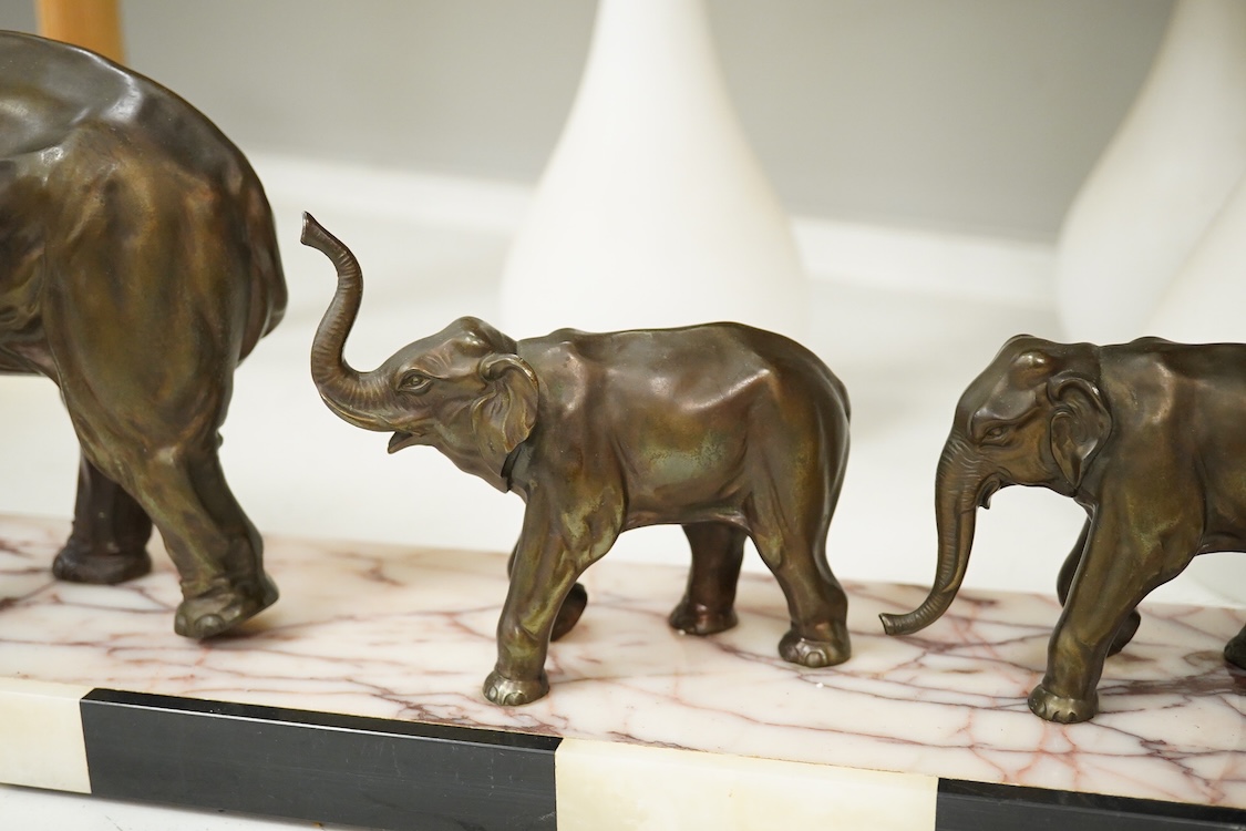 An Art Deco study, three spelter elephants, raised on marble and onyx base, 54cm wide